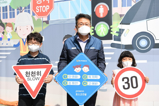 한성희(가운데) 포스코건설 사장이 지난 20일 '더샵 송도센터니얼'건설 현장 앞에서 어린이 교통사고 예방 및 교통안전 문화 정착을 위한 '어린이 교통안전 릴레이 챌린지'에 동참하고 있다. <포스코건설 제공>